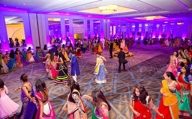 People dancing during an Indian wedding ceremony on a hall